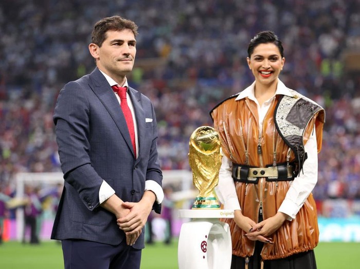 Deepika Padukone membawa trofi Piala Dunia 2022
