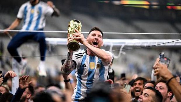 Argentina's forward #10 Lionel Messi lifts the FIFA World Cup Trophy as he celebrates with supporters winning the Qatar 2022 World Cup final football match between Argentina and France at Lusail Stadium in Lusail, north of Doha on December 18, 2022. (Photo by Kirill KUDRYAVTSEV / AFP)