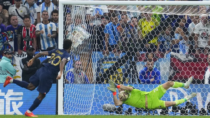 Argentinas goalkeeper Emiliano Martinez blocks a shot from Frances Kingsley Coman in a penalty shootout during the World Cup final soccer match between Argentina and France at the Lusail Stadium in Lusail, Qatar, Sunday, Dec. 18, 2022. (AP Photo/Natacha Pisarenko)