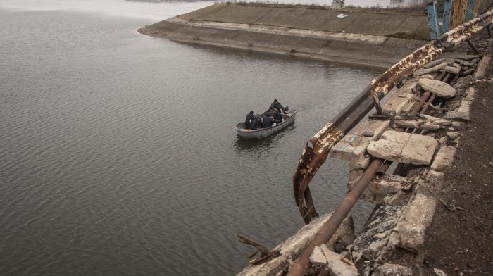 Jembatan Putus Dibom Rusia, Warga Kharkiv Nyeberang Naik Perahu KHARKIV, UKRAINE - DECEMBER 18: After Russian forces retreated from the area and destroyed the reservoir bridge, residents carry goods across the water by a free small taxi boat on December 18, 2022 in Staryi Saltiv, Kharkiv, Ukraine. Kharkiv, Ukraine's second city, was left without power for hours on Friday after the latest attack by Russia on the region's energy infrastructure. The city's mayor said it suffered