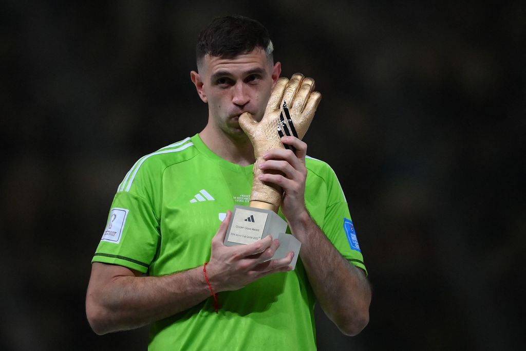 Kiper Argentina #23 Emiliano Martinez menerima penghargaan Sarung Tangan Emas pada upacara trofi Piala Dunia Qatar 2022 setelah pertandingan final sepak bola antara Argentina dan Prancis di Stadion Lusail di Lusail, utara Doha, Qatar, Minggu (18/12/2022).  Argentina menjadi juara Piala Dunia 2022 setelah menang adu penalti atas Prancis 4-2. (Photo by FRANCK FIFE/AFP via Getty Images)