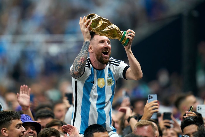 LUSAIL CITY, QATAR - DECEMBER 18: Lionel Messi of Argentina celebrates with the World Cup trophy after the FIFA World Cup Qatar 2022 Final match between Argentina and France at Lusail Stadium on December 18, 2022 in Lusail City, Qatar. (Photo by Quality Sport Images/Getty Images)