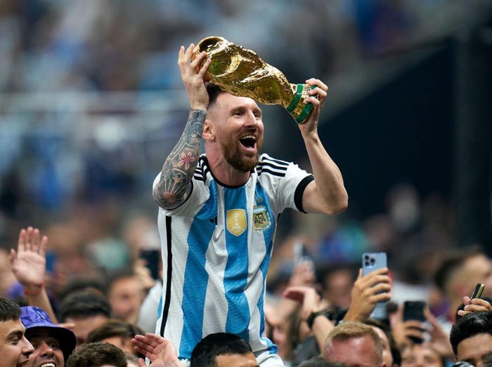 LUSAIL CITY, QATAR - DECEMBER 18: Lionel Messi of Argentina celebrates with the World Cup trophy after the FIFA World Cup Qatar 2022 Final match between Argentina and France at Lusail Stadium on December 18, 2022 in Lusail City, Qatar. (Photo by Quality Sport Images/Getty Images)