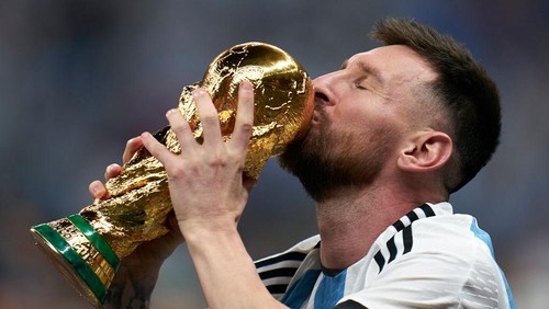 LUSAIL CITY, QATAR - DECEMBER 18: Lionel Messi of Argentina kisses the FIFA World Cup Qatar 2022 Winners Trophy after the FIFA World Cup Qatar 2022 Final match between Argentina and France at Lusail Stadium on December 18, 2022 in Lusail City, Qatar. (Photo by Quality Sport Images/Getty Images)