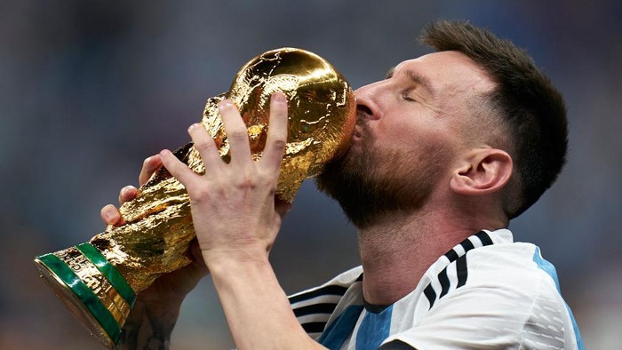 LUSAIL CITY, QATAR - DECEMBER 18: Lionel Messi of Argentina kisses the FIFA World Cup Qatar 2022 Winners Trophy after the FIFA World Cup Qatar 2022 Final match between Argentina and France at Lusail Stadium on December 18, 2022 in Lusail City, Qatar. (Photo by Quality Sport Images/Getty Images)