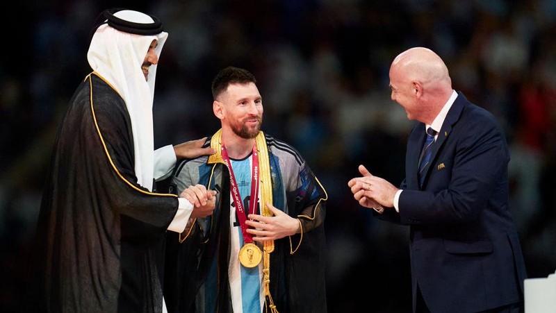 LUSAIL CITY, QATAR - DECEMBER 18: Lionel Messi of Argentina receives a Robe from Tamim bin Hamad Al Thani the Emir of Qatar  during the FIFA World Cup Qatar 2022 Final match between Argentina and France at Lusail Stadium on December 18, 2022 in Lusail City, Qatar. (Photo by Quality Sport Images/Getty Images)