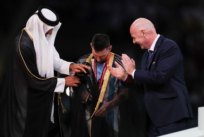 Sebelum mengangkat trofi kemenangan Golden Ball Messi diberi selamat oleh Presiden FIFA Gianni Infantino kemudian dipakaikan jubah oleh Emir Qatar Sheikh Tamim bin Hamad Al Thani sebagai kepala negara.Foto: Getty Images/Ian MacNicol