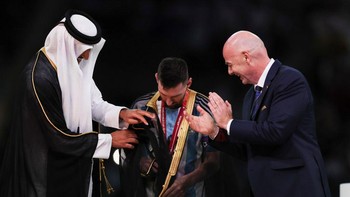 Jubah itu dikenakan Messi setelah diberi oleh Emir Qatar Sheikh Tamim bin Hamad Al Thani sebelum seremoni pengangkatan trofi Piala Dunia 2022. Foto: Getty Images/Ian MacNicol