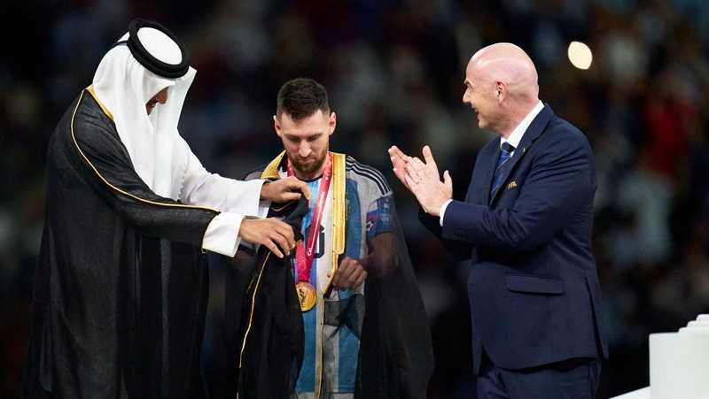LUSAIL CITY, QATAR - DECEMBER 18: Lionel Messi of Argentina is presented with their FIFA World Cup Qatar 2022 trophy after the team's victory by Gianni Infantino, President of FIFA and Tamim bin Hamad Al Thani, Emir of Qatar, following the FIFA World Cup Qatar 2022 Final match between Argentina and France at Lusail Stadium on December 18, 2022 in Lusail City, Qatar. (Photo by Juan Luis Diaz/Quality Sport Images/Getty Images)