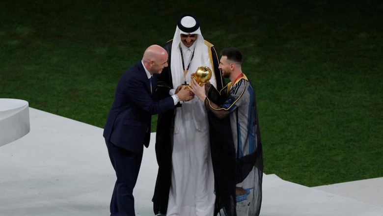 Lionel Messi mengenakan jubah bisht Lionel Messi mengenakan jubah bisht saat menerima trofi Piala Dunia dari Presiden FIFA Gianni Infantino dan disaksikan Emir Sheikh Tamim bin Hamad al-Thani di Stadion Lusail, Doha.