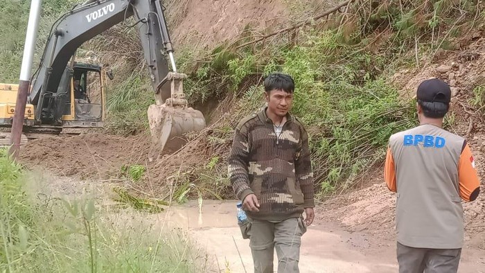 Material longsor di jalan menuju Desa Miallo, Tana Toraja dibersihkan.