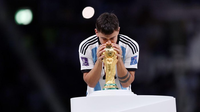 LUSAIL CITY, QATAR - DECEMBER 18: Paulo Dybala of Argentina kisses the FIFA World Cup winning trophy during the award ceremony following the FIFA World Cup Qatar 2022 Final match between Argentina and France at Lusail Stadium on December 18, 2022 in Lusail City, Qatar. (Photo by Clive Brunskill/Getty Images)