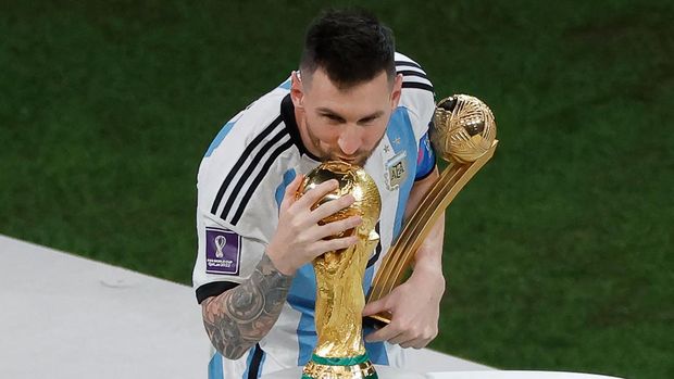 Pemain depan Argentina #10 Lionel Messi mencium trofi Piala Dunia setelah menerima penghargaan Bola Emas pada upacara trofi Piala Dunia Qatar 2022 setelah pertandingan final sepak bola Piala Dunia Qatar 2022 antara Argentina dan Prancis Pemain depan Argentina #10 Lionel Messi mencium trofi Piala Dunia setelah menerima penghargaan Bola Emas pada upacara trofi Piala Dunia Qatar 2022 setelah pertandingan final sepak bola Piala Dunia Qatar 2022 antara Argentina dan Prancis di Stadion Lusail di Lusail, utara Doha, Qatar, Minggu (18/12/2022). Argentina menjadi juara Piala Dunia 2022 setelah menang adu penalti atas Prancis 4-2. (Photo by ODD ANDERSEN/AFP via Getty Images)