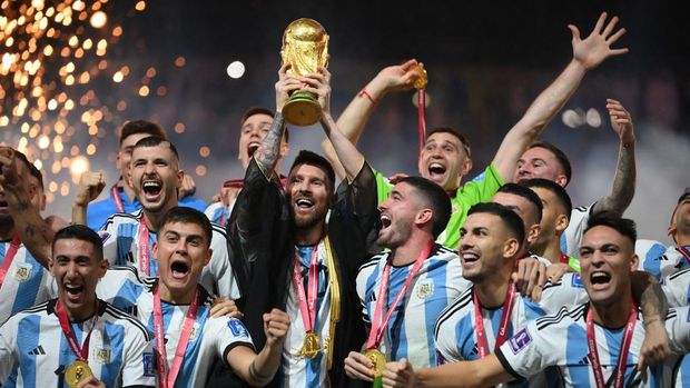 Penyerang Argentina #10 Lionel Messi mengangkat trofi Piala Dunia pada upacara trofi Piala Dunia Qatar 2022 setelah pertandingan final sepak bola antara Argentina dan Prancis di Stadion Lusail di Lusail, utara Doha, Qatar, Minggu (18/12/2022). Argentina menjadi juara Piala Dunia 2022 setelah menang adu penalti atas Prancis 4-2. (Photo by FRANCK FIFE/AFP via Getty Images)