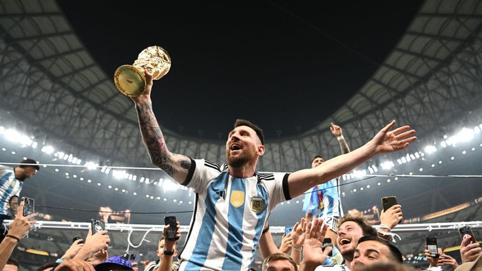 LUSAIL CITY, QATAR - DECEMBER 18:  Lionel Messi of Argentina celebrates with the World Cup Trophy after winning the FIFA World Cup Qatar 2022 Final match between Argentina and France at Lusail Stadium on December 18, 2022 in Lusail City, Qatar. (Photo by Shaun Botterill - FIFA/FIFA via Getty Images)
