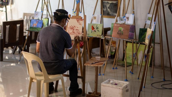 Filipino artist Elito Circa, 52, paints with his own blood in his studio in Nueva Ecija province, Philippines November 29, 2022. REUTERS/Eloisa Lopez