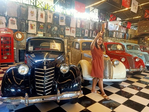 Salah satu pengunjung berfoto di depan koleksi mobil klasik Kebon Vintage Cars Bali.