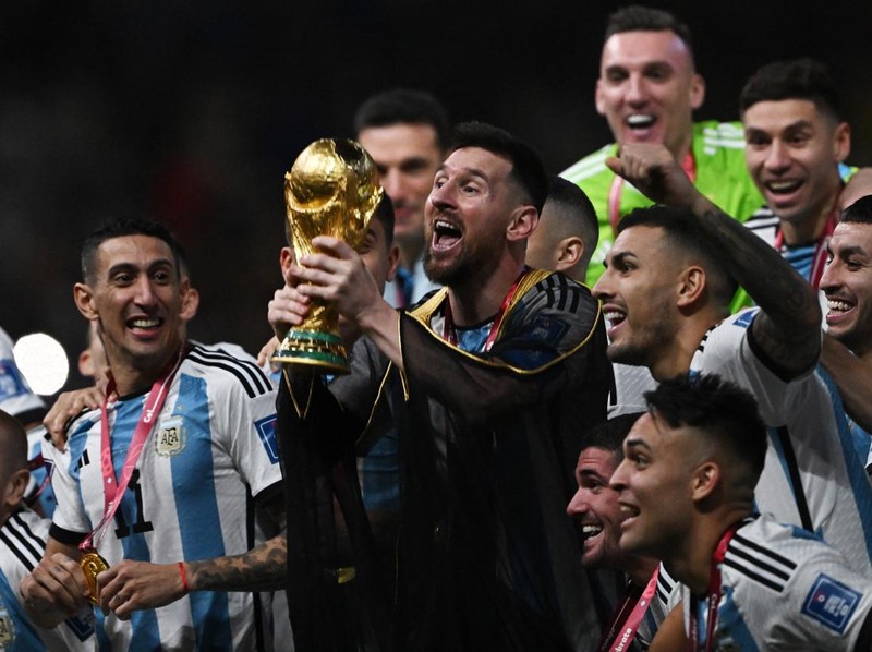 Soccer Football - FIFA World Cup Qatar 2022 - Final - Argentina v France - Lusail Stadium, Lusail, Qatar - December 18, 2022   Argentina's Lionel Messi lifts the World Cup trophy alongside teammates as they celebrate after winning the World Cup REUTERS/Dylan Martinez