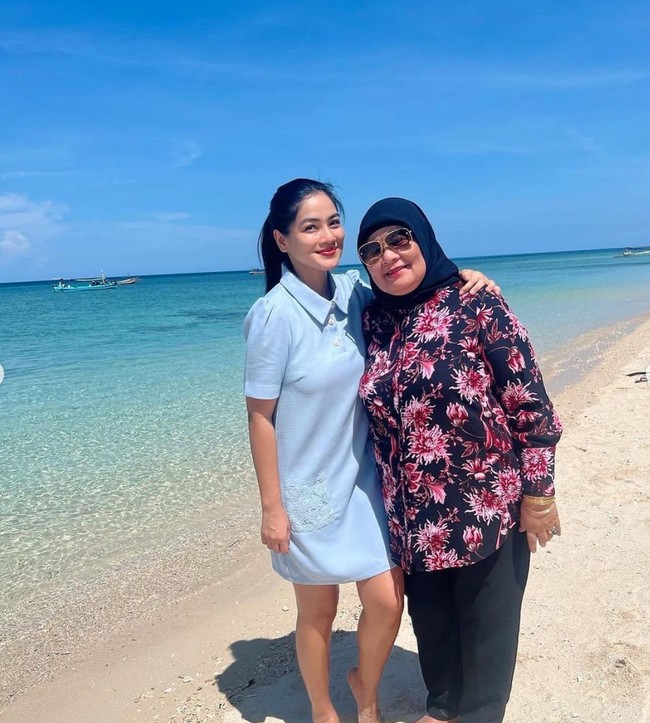 Tak seperti artis-artis lain, Titi tetap memilih mengenakan baju-baju tertutup saat berada di pantai. Begini potretnya bersama sang bunda. Foto: Instagram/@titi_kamall