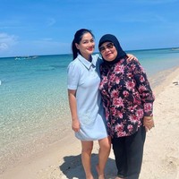 Tak seperti artis-artis lain, Titi tetap memilih mengenakan baju-baju tertutup saat berada di pantai. Begini potretnya bersama sang bunda. Foto: Instagram/@titi_kamall