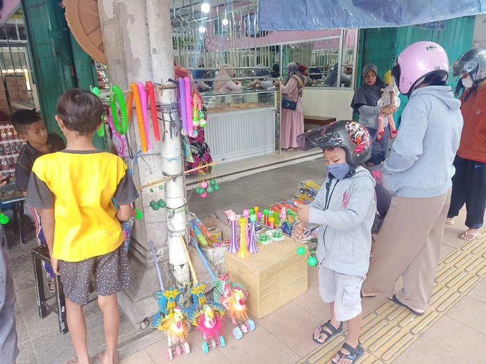 Warga saat membeli permainan tek-tekan di Pasar Umum Negara, Kecamatan Jembrana, Kabupaten Jembrana, Senin (19/12/2022). (I Putu Adi Budiastrawan/DetikBali).