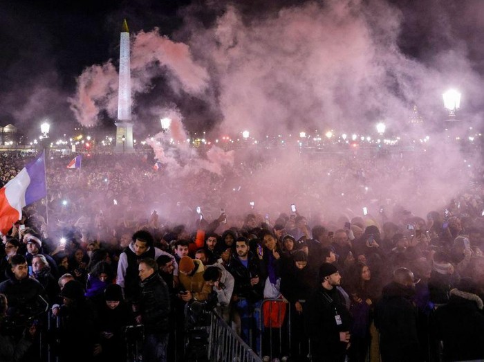 Fans light flares as they wait at the Place de la Concorde for the arrival of the French national football team at the Hotel de Crillon, a day after the Qatar 2022 World Cup final match against Argentina, in central Paris on December 19, 2022. (Photo by Geoffroy Van der Hasselt / AFP) (Photo by GEOFFROY VAN DER HASSELT/AFP via Getty Images)