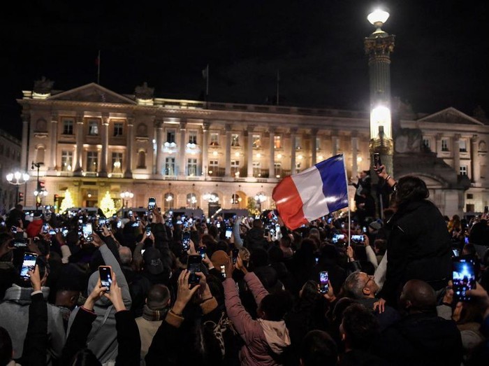 Fans take pictures as as they wait at the Place de la Concorde for the arrival of the French national football team at the Hotel de Crillon, a day after the Qatar 2022 World Cup final match against Argentina, in central Paris on December 19, 2022. (Photo by JULIEN DE ROSA / AFP) (Photo by JULIEN DE ROSA/AFP via Getty Images)