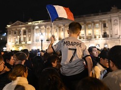 Rakyat Prancis menyalakan suar dan mengibarkan bendera Prancis di depan Hotel de Crillon (Foto: Anadolu Agency via Getty Images/Anadolu Agency)