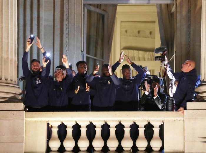PARIS, FRANCE - DECEMBER 19: Olivier Giroud and Antoine Griezmann of Team France react with fans at the balcony of the Hotel de Crillon during the meeting with French fans at Place de la Concorde on December 19, 2022 in Paris, France. (Photo by Xavier Laine/Getty Images)