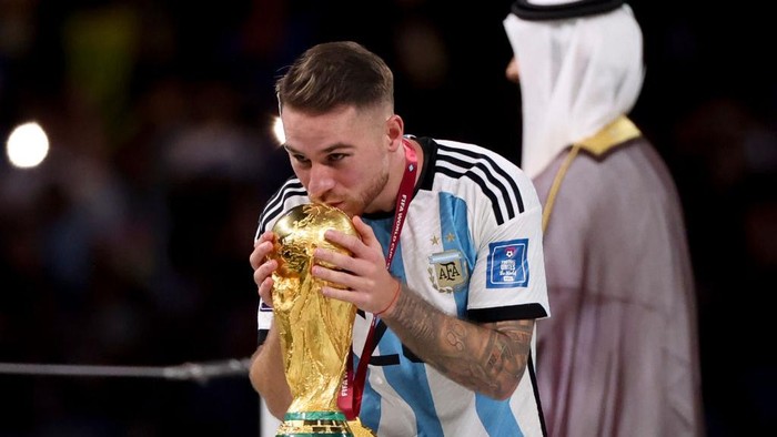 LUSAIL CITY, QATAR - DECEMBER 18: Alexis Mac Allister of Argentina kissing the World Cup during the trophy ceremony following the FIFA World Cup Qatar 2022 Final match between Argentina and France at Lusail Stadium on December 18, 2022 in Lusail City, Qatar. (Photo by Jean Catuffe/Getty Images)