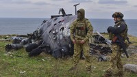 Kini Pulau Ular kembali dikuasai oleh Ukraina. Tampak dua tentara Ukraina foto bersama dengan latar belakang helikopter Rusia yang rusak.