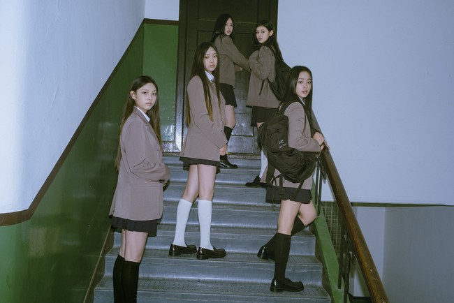 Dalam foto-foto yang dirilis HYBE, sejumlah personel NewJeans memakai koleksi tas sekolah keluaran brand Kanada, Arcteryx. Minji memakai ‘Mantis 26 Backpack’ seharga $149 atau Rp 2,3 jutaan. Sedangkan Danielle memakai Heliad 15 Backpack seharga $60 atau Rp 938 ribuan. Foto: dok. HYBE