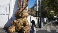 Warga melihat kelinci raksasa di pinggir jalan Hangzhou, China, Selasa (20/12/2022).