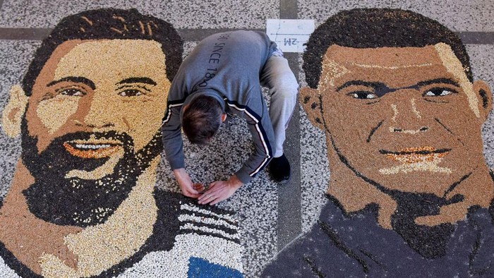 TOPSHOT - Kosovar artist Alkent Pozhegu works on the last details of his mosaic, made with grain and seeds on the ground, depicting Argentina's forward Lionel Messi (L) and France's forward Kylian Mbappe in the town of Gjakova on December 17, 2022, on the eve of the Qatar 2022 World Cup final match between Argentina and France. - RESTRICTED TO EDITORIAL USE - MANDATORY MENTION OF THE ARTIST UPON PUBLICATION - TO ILLUSTRATE THE EVENT AS SPECIFIED IN THE CAPTION (Photo by Armend NIMANI / AFP) / RESTRICTED TO EDITORIAL USE - MANDATORY MENTION OF THE ARTIST UPON PUBLICATION - TO ILLUSTRATE THE EVENT AS SPECIFIED IN THE CAPTION / RESTRICTED TO EDITORIAL USE - MANDATORY MENTION OF THE ARTIST UPON PUBLICATION - TO ILLUSTRATE THE EVENT AS SPECIFIED IN THE CAPTION (Photo by ARMEND NIMANI/AFP via Getty Images)