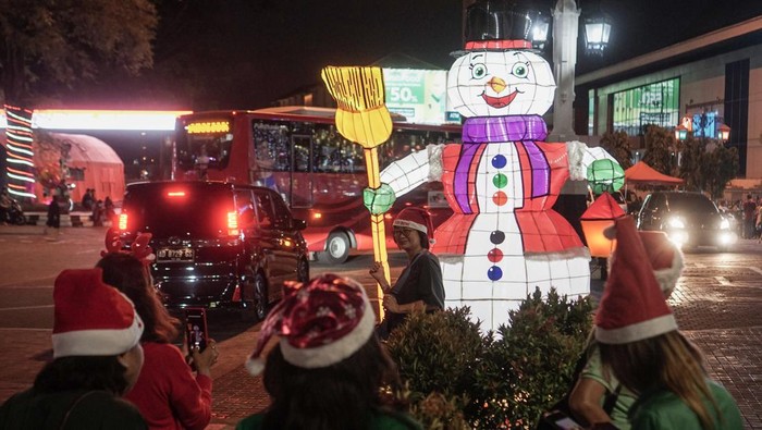 Warga berfoto dengan latar belakang lampion dekorasi bertema Natal di Balai Kota, Solo, Jawa Tengah, Selasa (20/12/2022). Pemasangan lampion tersebut untuk memeriahkan perayaan Natal dan Tahun Baru di Kota Solo. ANTARA FOTO/Mohammad Ayudha/aww.