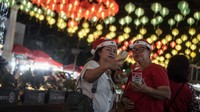 Warga berfoto dengan latar belakang lampion dekorasi bertema Natal di Balai Kota, Solo, Jawa Tengah, Selasa (20/12/2022).