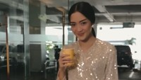Pakai gaun cantik, Ririn tampaknya akan menghadiri sebuah acara formal. Ia melengkapi momennya sambil menyeruput minuman hangat.