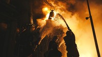 Petugas damkar berusaha memadamkan api yang membakar fasilitas infrastruktur setelah serangan pesawat tak berawak Rusia di Kyiv. Pavel Petrov, SESU via AP.