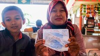 Seorang penumpang menunjukkan tiket bus.  