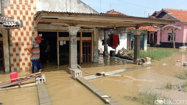 Warga di tengah terjangan banjir rob di Indramayu.
