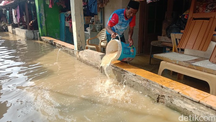 Warga di tengah terjangan banjir rob di Indramayu.