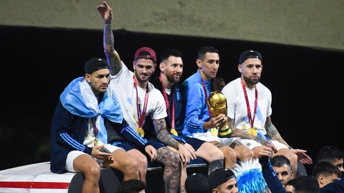 BUENOS AIRES, ARGENTINA - DECEMBER 20: (L-R) Leandro Paredes, Rodrigo De Paul, Lionel Messi, Angel Di Maria and Nicolas Otamendi celebrate on the bus during the arrival of the Argentina men's national football team after winning the FIFA World Cup Qatar 2022 on December 20, 2022 in Buenos Aires, Argentina. (Photo by Rodrigo Valle/Getty Images)