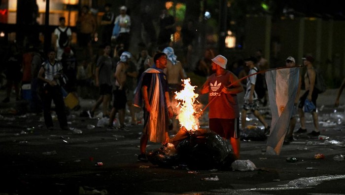 Fans of Argentina set fire to rubbish bags following the celebration of the teams arrival from the Qatar 2022 World Cup tournament, which left millions disappointed when an open-top bus parade had to be abandoned due to the massive crowds, on December 20, 2022, in the surroundings of the Obelisk in Buenos Aires. (Photo by Luis ROBAYO / AFP) (Photo by LUIS ROBAYO/AFP via Getty Images)