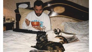 Freddie Mercury di tempat tidur ditemani kucingnya pada 1980-an. Foto: Twitter/HistoricalStuff