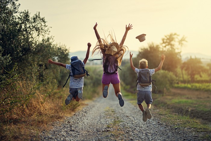 Brothers and sister hiking in Tuscany, Italy. Kids are jumping with joy on dirt road.
Nikon D850