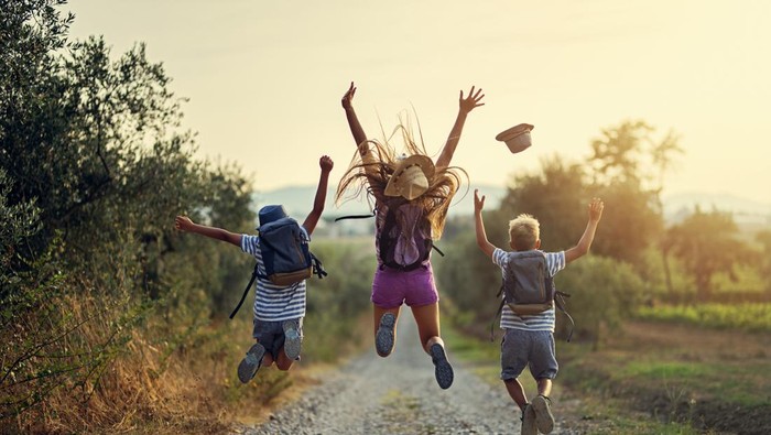 Brothers and sister hiking in Tuscany, Italy. Kids are jumping with joy on dirt road.
Nikon D850
