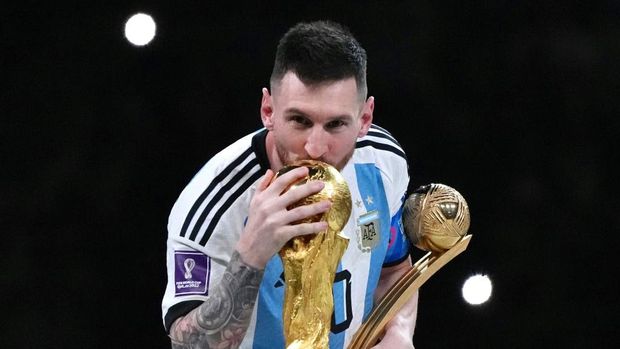 LUSAIL CITY, QATAR - DECEMBER 18: Adidas Golden Ball winner Lionel Messi of Argentina kisses the FIFA World Cup Winner's Trophy at the award ceremony following the FIFA World Cup Qatar 2022 Final match between Argentina and France at Lusail Stadium on December 18, 2022 in Lusail City, Qatar. (Photo by Cui Nan/China News Service/VCG via Getty Images)