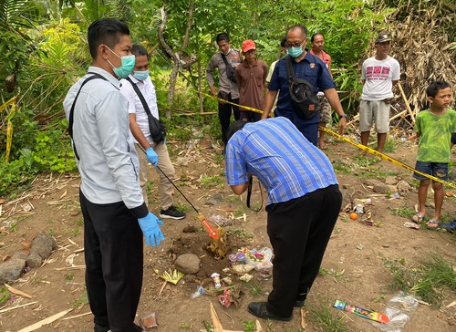 Polisi melakukan olah TKP  di kuburan Desa Adat Seraya, Karangasem, Bali. Jasad orok laki-laki yang ditemukan di depan balai Banjar Pauman, Desa Seraya, akhirnya dikubur kembali.