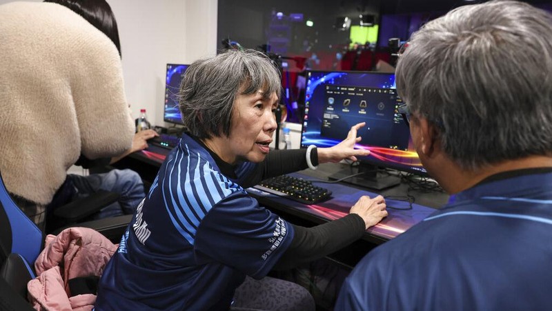 Chiang Yi-Shu watches the screen during the competition at Hungkuang University in Taichung, Taiwan on Saturday, Dec. 17, 2022.Chiang is one of the League of Legends players on Hungkung Evergreen Gaming's team, established this summer. The team, whose members range from 62 to 69 years old, was founded by Huang Jianji, the director of the department of Multimedia Game development and application of Hungkuang University. They competed in their first-ever video game tournament Saturday at the university. (AP photo/I-Hwa Cheng)