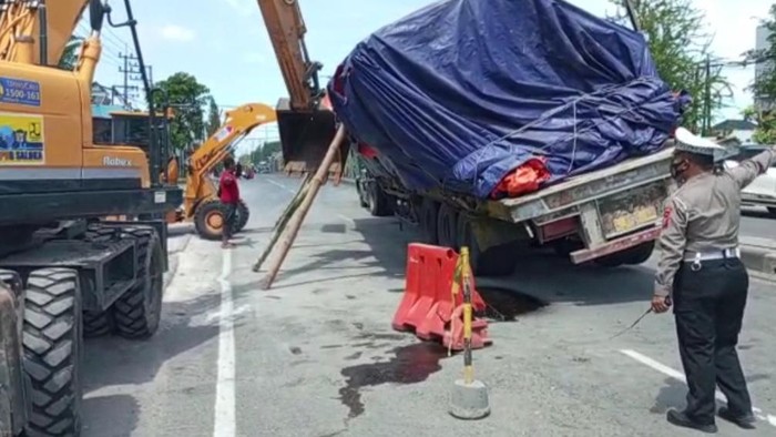 Truk muatan besi miring di jalan poros nasional Lamongan
